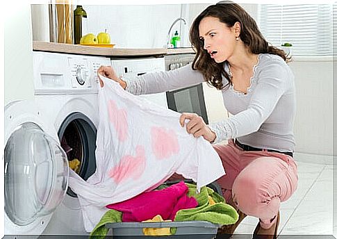 The woman, frightened by the stains, washes the clothes