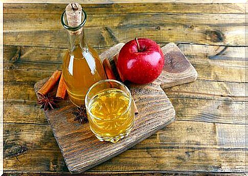 Apple vinegar and apple on a board