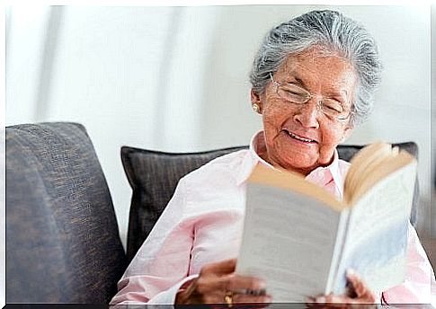 The elderly woman is reading the book